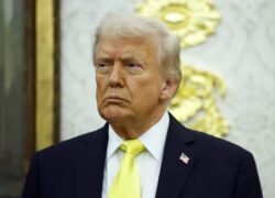 Donaldas Trumpas su tamsiu kostiumu ir geltonu kaklaraiščiu
