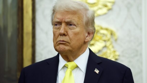 Donaldas Trumpas su tamsiu kostiumu ir geltonu kaklaraiščiu