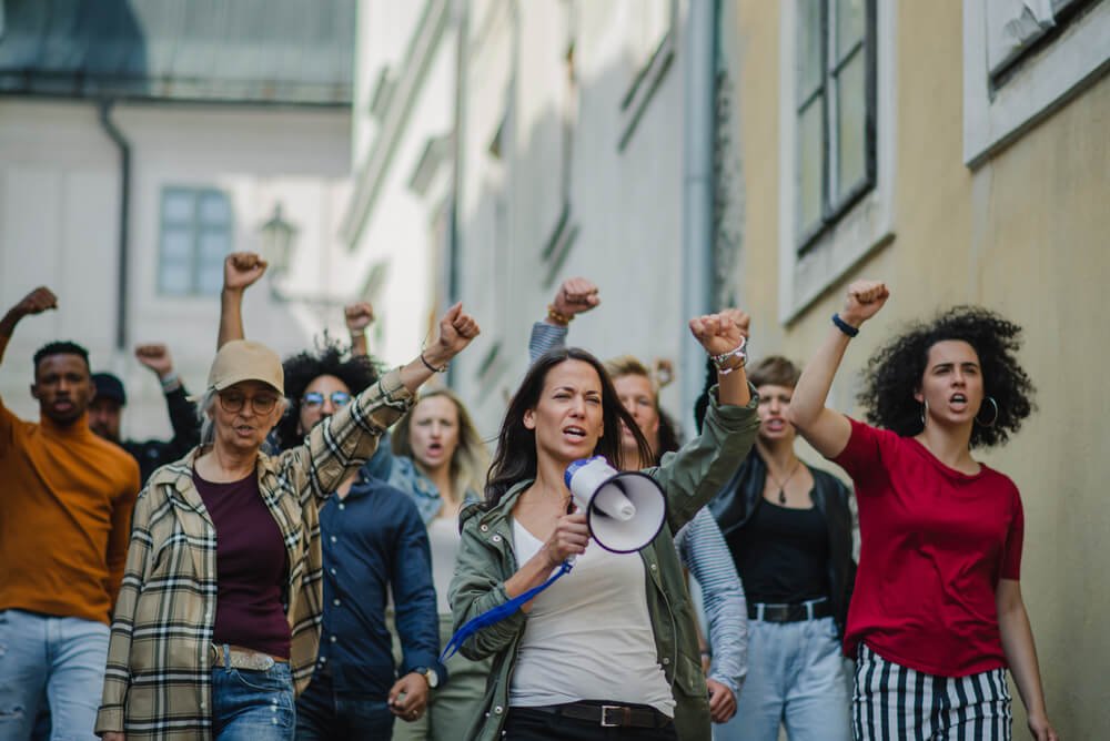 Konfliktai „violetinėje“ stovykloje - asociatyvinė protestuojančių žmonių nuotrauka