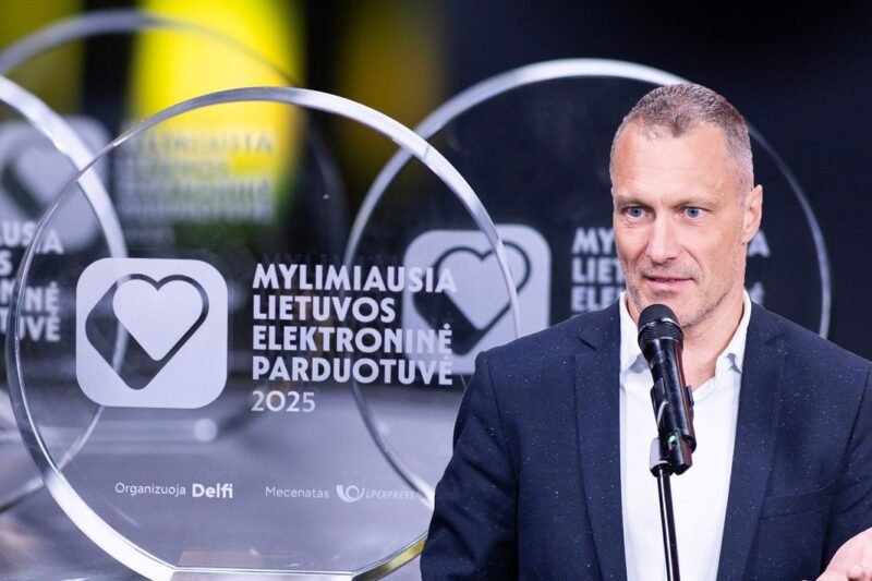 Vyras kalba prie mikrofono šalia apdovanojimo „Mylimiausia Lietuvos elektroninė parduotuvė“