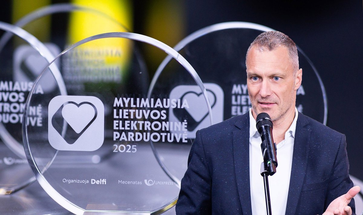 Vyras kalba prie mikrofono šalia apdovanojimo „Mylimiausia Lietuvos elektroninė parduotuvė“