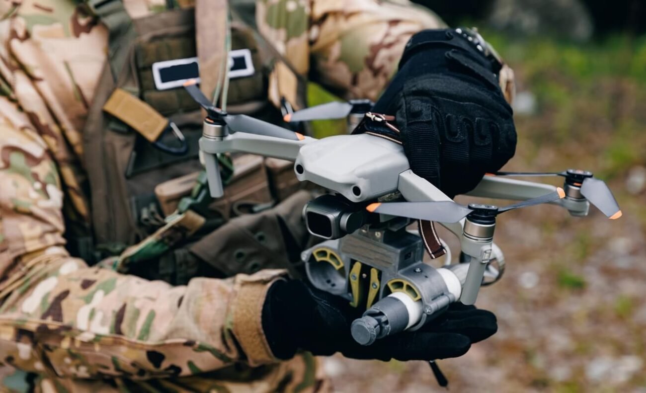 Rusijos raketų ir dronų ataka Ukrainoje, kariškis rankose laiko bepilotį orlaivį