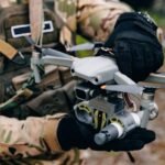 Rusijos raketų ir dronų ataka Ukrainoje, kariškis rankose laiko bepilotį orlaivį