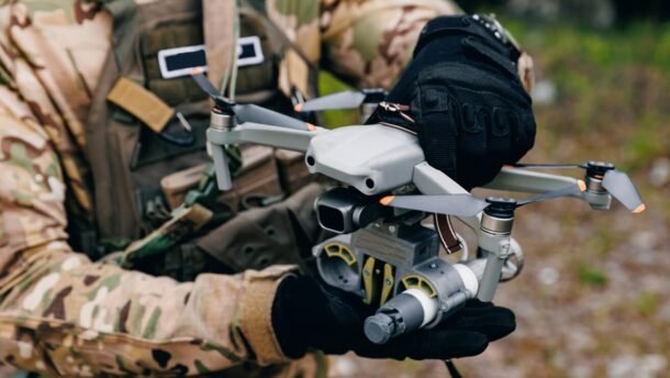 Rusijos raketų ir dronų ataka Ukrainoje, kariškis rankose laiko bepilotį orlaivį