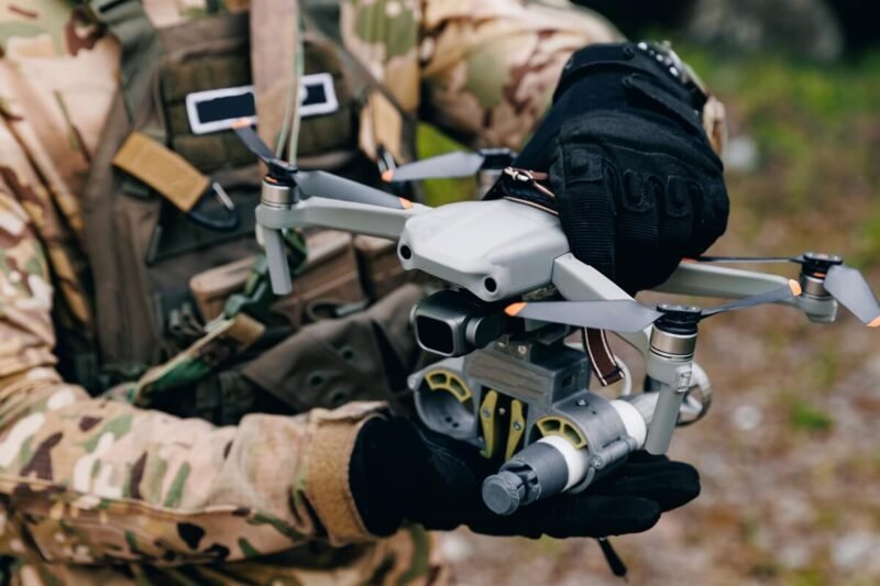 Rusijos raketų ir dronų ataka Ukrainoje, kariškis rankose laiko bepilotį orlaivį