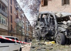 Smarkiai apgadintas automobilis prie daugiabučių namų ir įspėjamosios juostos