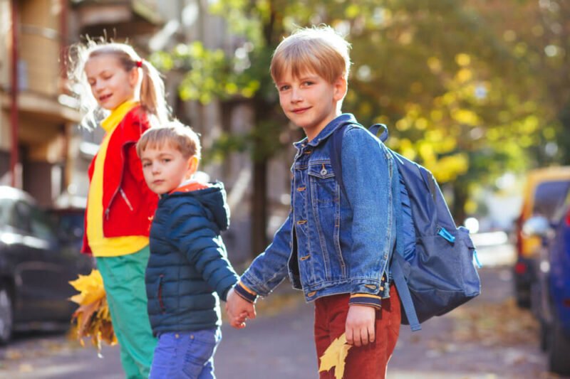 Saugus vaikų elgesys gatvėje, vaikai su kuprinėmis eina į mokyklą