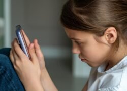 Vaikų saugumas internete - mergaitė naudojasi telefonu