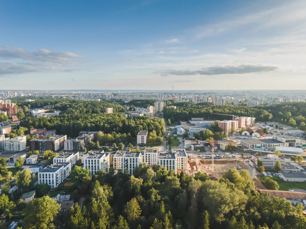 Vilniaus miesto panorama iš paukščio skrydžio, apsupta želdynų ir naujų statybų