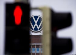 Volkswagen logotipas ir raudonai šviečiantis eismo signalas