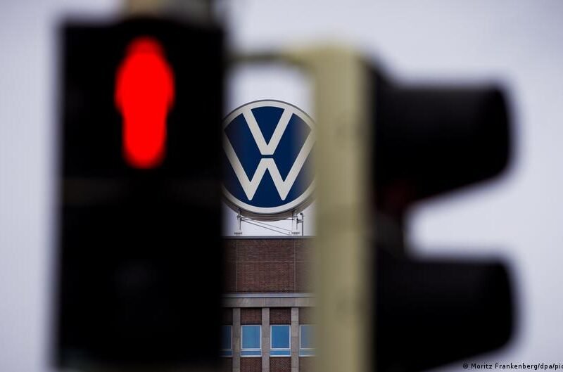 Volkswagen logotipas ir raudonai šviečiantis eismo signalas