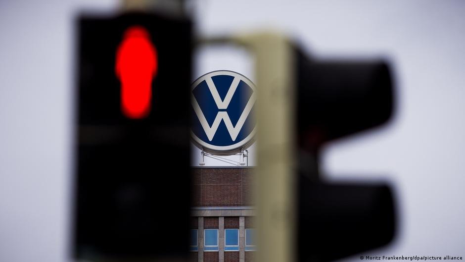 Volkswagen logotipas ir raudonai šviečiantis eismo signalas