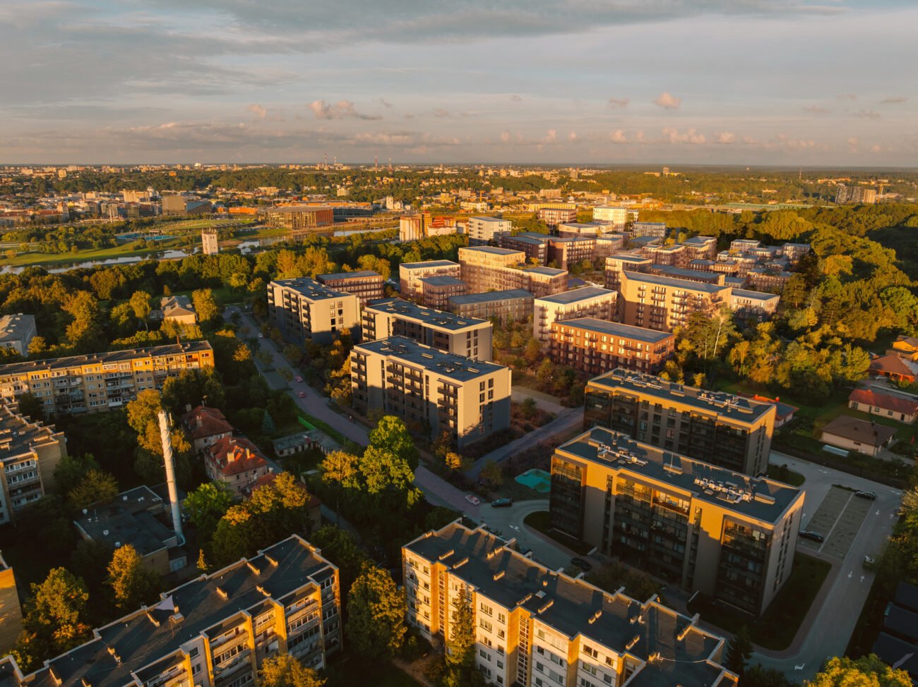 Iš paukščio skrydžio matomas gyvenamųjų namų kvartalas ir žaliuojanti miesto aplinka