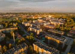 Iš paukščio skrydžio matomas gyvenamųjų namų kvartalas ir žaliuojanti miesto aplinka