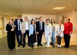 Medicinos darbuotojų ir svečių grupė ligoninės koridoriuje