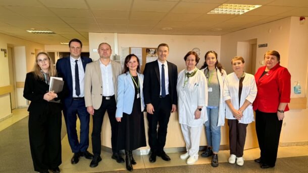 Medicinos darbuotojų ir svečių grupė ligoninės koridoriuje