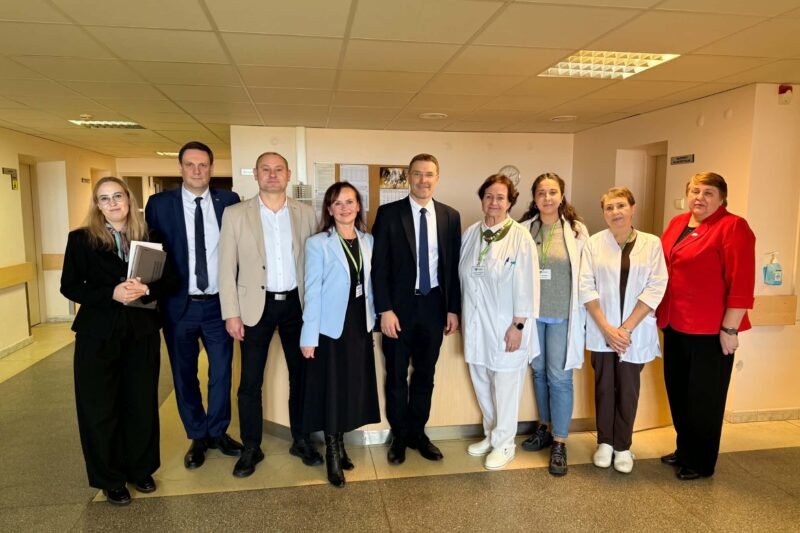 Medicinos darbuotojų ir svečių grupė ligoninės koridoriuje