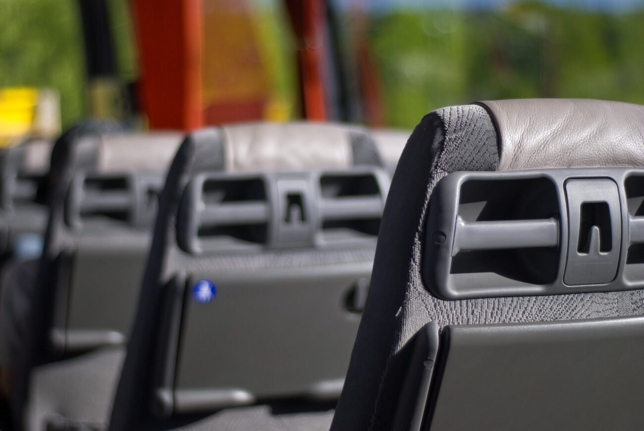 Autobuso sėdynių atlošai su integruotais staleliais ir laikikliais