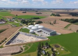 Biodujų gamybos kompleksas su kupoliniais rezervuarais tarp dirbamų laukų