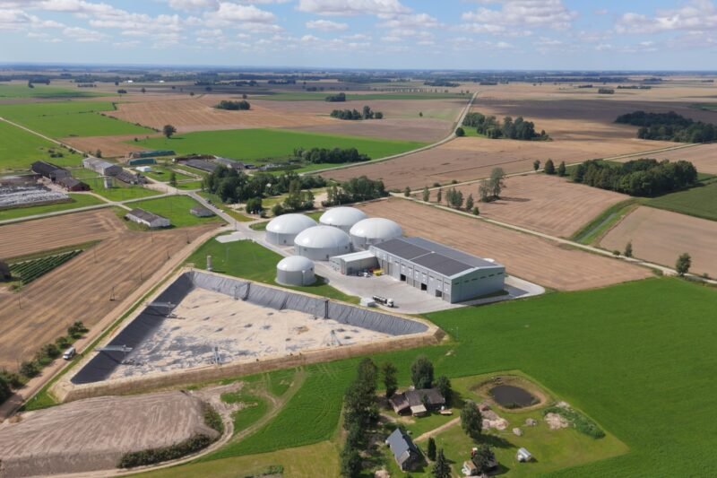 Biodujų gamybos kompleksas su kupoliniais rezervuarais tarp dirbamų laukų