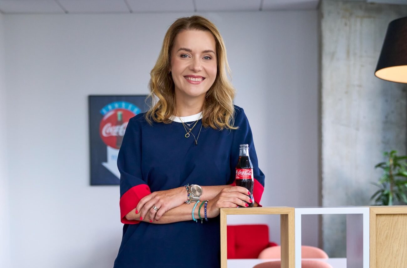 Moteris biure laiko Coca - Cola buteliuką
