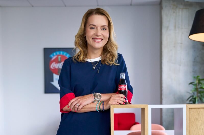 Moteris biure laiko Coca - Cola buteliuką