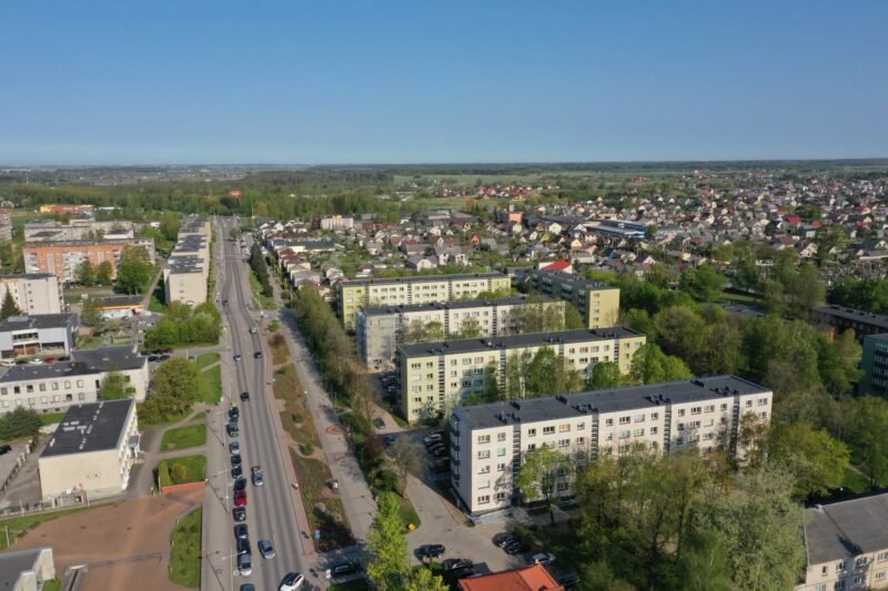 Iš paukščio skrydžio matomas daugiabučių rajonas su gatvėmis ir privačiais namais