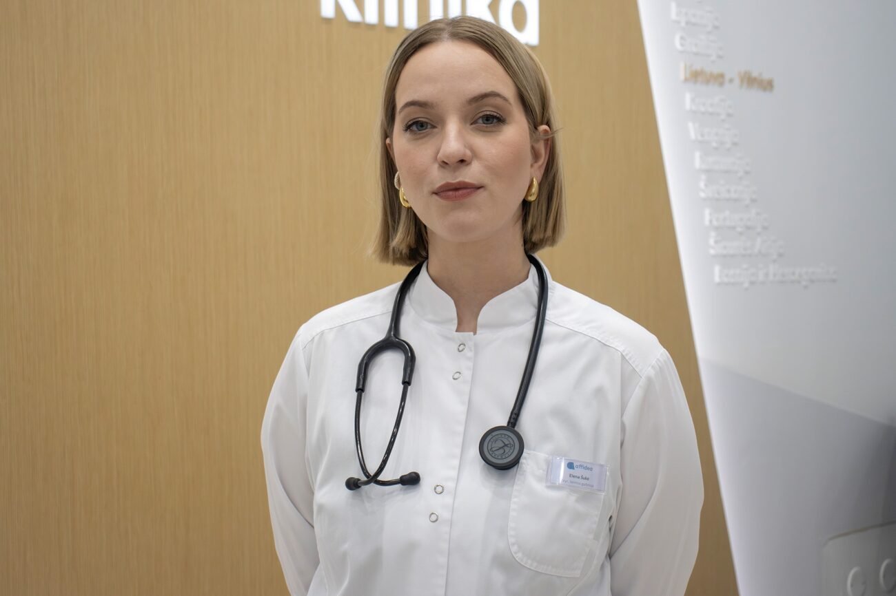 Gydytoja, vilkinti baltą medicininį chalatą ir seginti stetoskopą