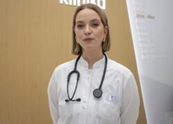 Gydytoja, vilkinti baltą medicininį chalatą ir seginti stetoskopą