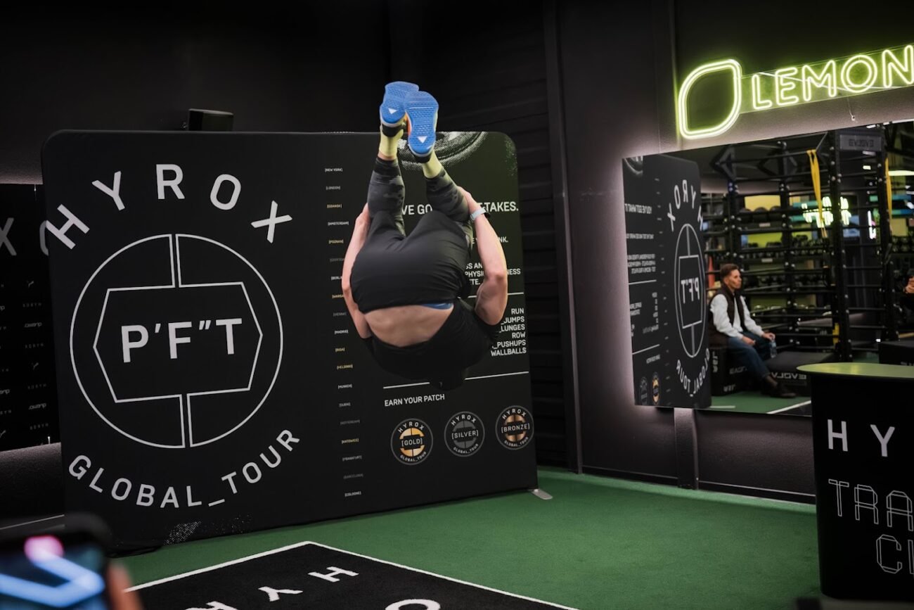 Sportuojantis žmogus HYROX treniruočių erdvėje šalia P’FT sienelės