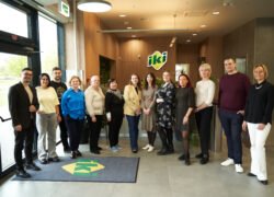 Žmonių grupė stovi prie „Iki“ parduotuvės įėjimo
