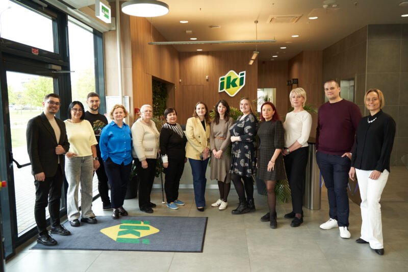 Žmonių grupė stovi prie „Iki“ parduotuvės įėjimo