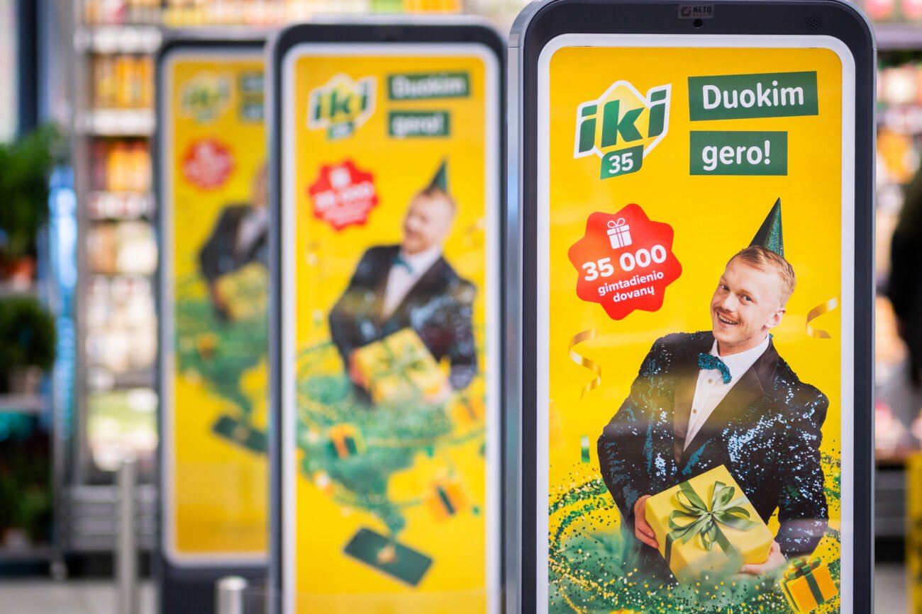 „Iki“ reklaminis stendas su dovaną laikančiu vyru