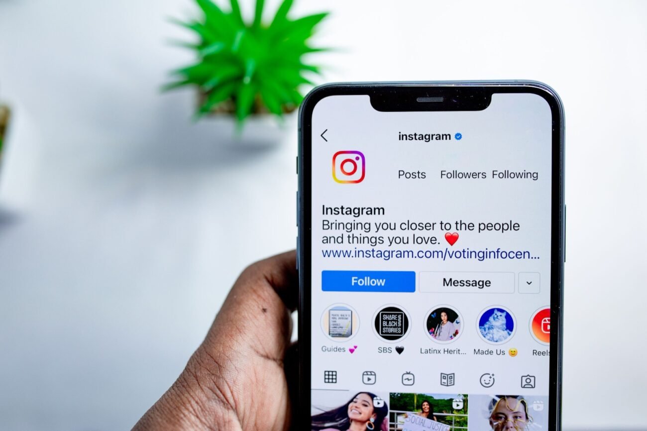 Ranka laiko išmanųjį telefoną su atidarytu Instagram profiliu