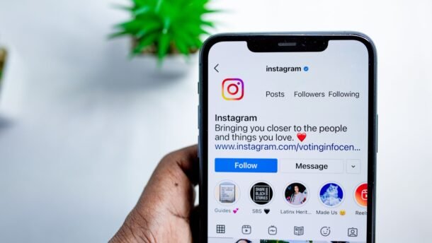 Ranka laiko išmanųjį telefoną su atidarytu Instagram profiliu