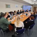 Institucijų atstovai susirinkę prie stalo dalyvauja darbiniame susitikime