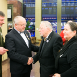 Juozas Olekas spaudžia ranką Vytautui Landsbergiui, šalia stovi uniformuoti vyrai