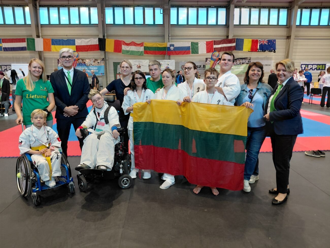 Lietuvos para - karate rinktinės nariai su Lietuvos vėliava sporto salėje