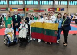 Lietuvos para - karate rinktinės nariai su Lietuvos vėliava sporto salėje