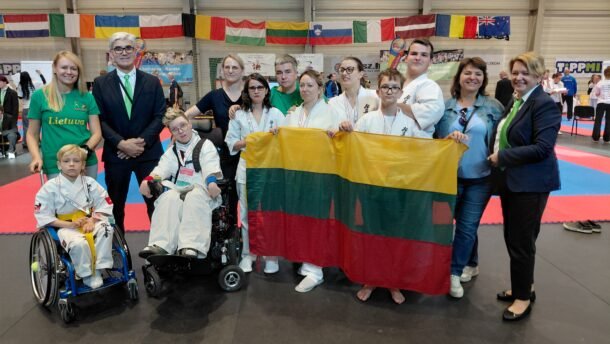 Lietuvos para - karate rinktinės nariai su Lietuvos vėliava sporto salėje