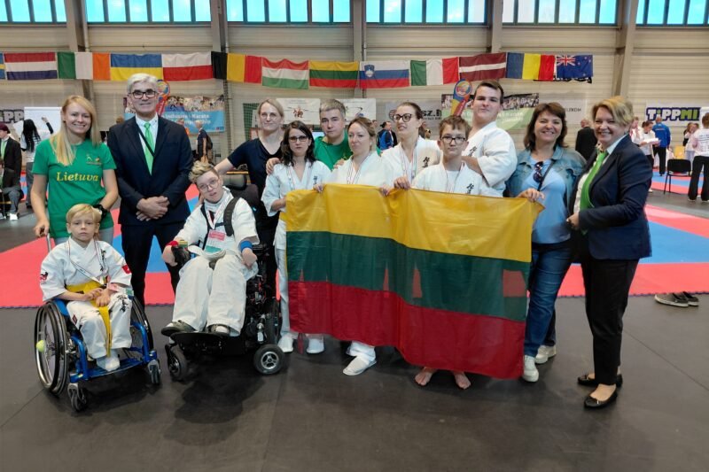 Lietuvos para - karate rinktinės nariai su Lietuvos vėliava sporto salėje