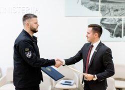 Uniformuotas vyras ir vyras su kostiumu spaudžia vienas kitam rankas