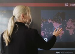 Moteris liečia ekrane rodomą skaitmeninį pasaulio žemėlapį