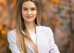 Ilgaplaukė moteris šviesiu švarku rudeniškame fone