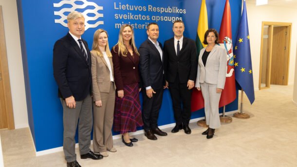 Šeši žmonės pozuoja prie Lietuvos Respublikos sveikatos apsaugos ministerijos sienelės