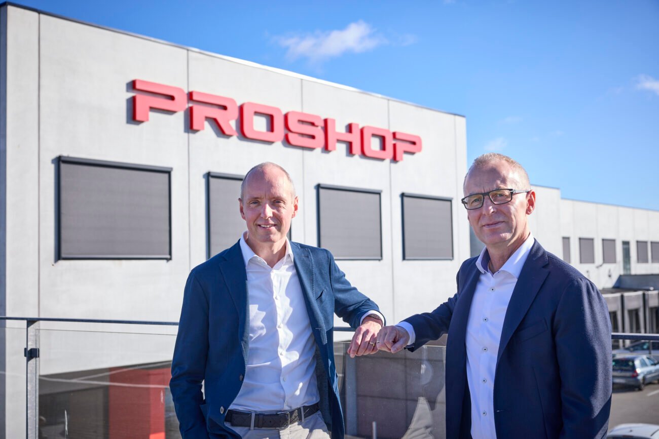 Du vyrai stovi priešais „Proshop“ pastatą su įmonės logotipu