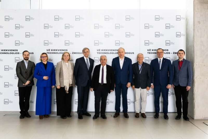 Dešimt renginio dalyvių pozuoja prie konferencijos sienelės