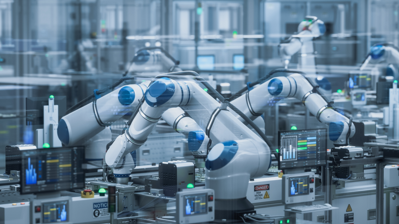 Pramoninėje gamykloje dirbančios robotinės rankos prie gamybos įrangos