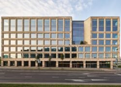 Modernus daugiaaukštis verslo pastatas su stikliniais langais prie miesto gatvės