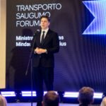 Vyras kostiumu kalba prie mikrofono transporto saugumo forume